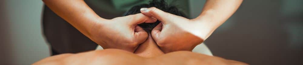 A man being treated with physical therapy for throbbing neck pain.