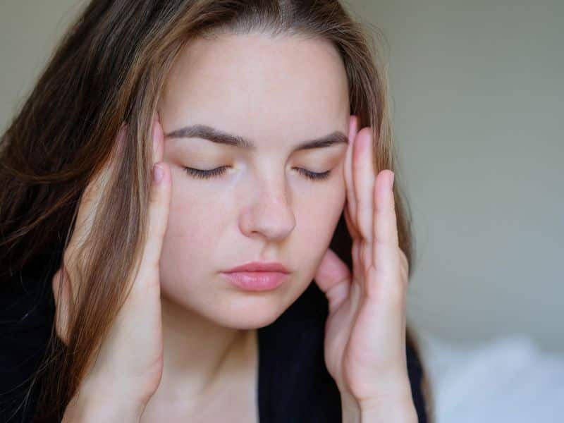 A young woman in pain and in need of Botox for her hormonal migraines.