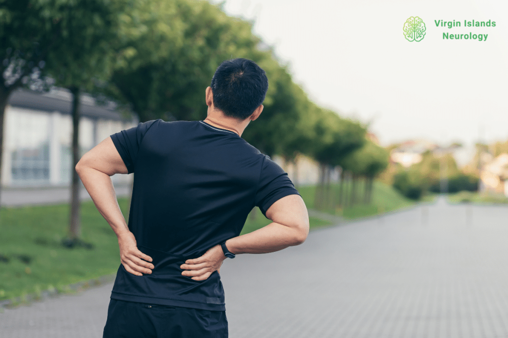 A man experiencing lower back pain while out on a walk outside in the U.S Virgin Islands.